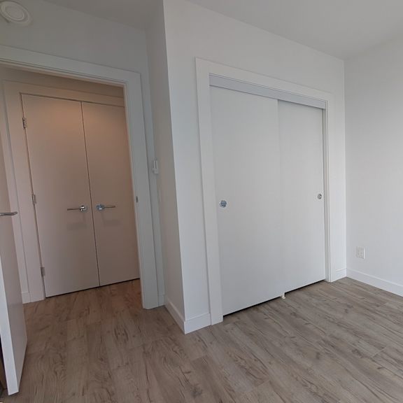 a room with a white door and a wooden floor.