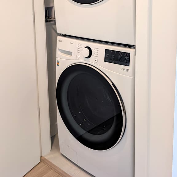two white front loading washing machines in a small room.