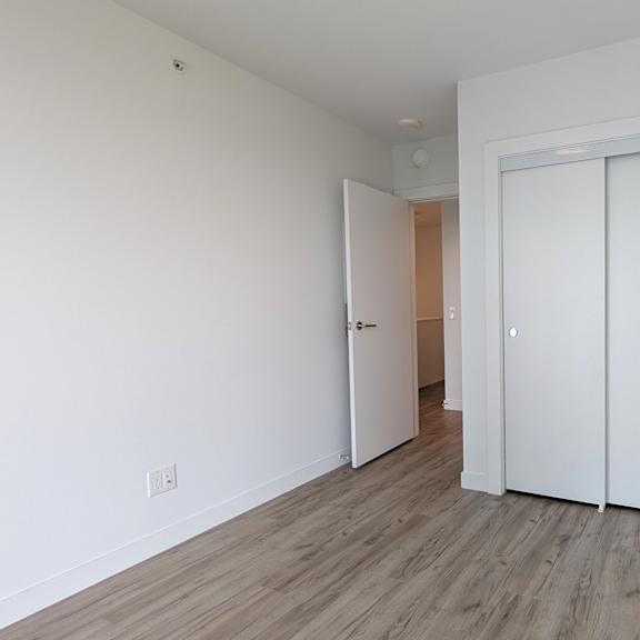 a room with a white door and a wooden floor.