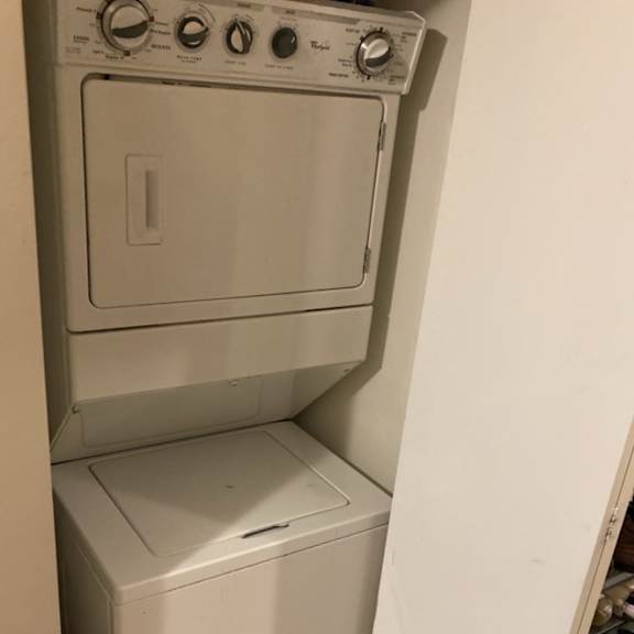 a white dryer and washer are stacked on top of each other.