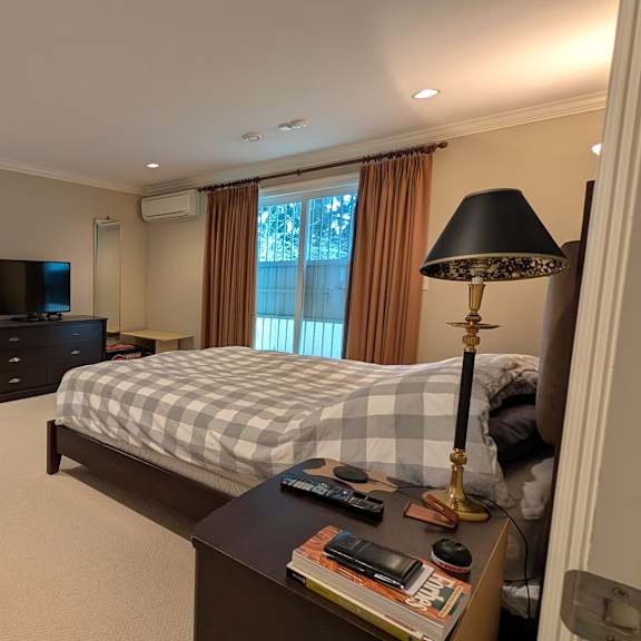a bedroom with a bed, chair, and window.
