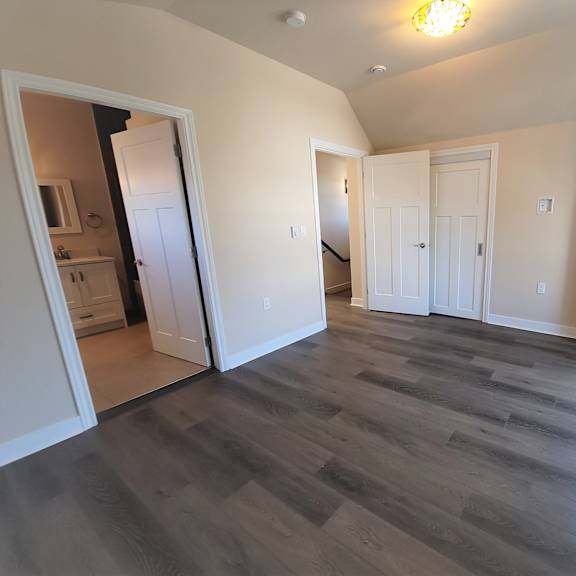 a room with a wooden floor and white walls.