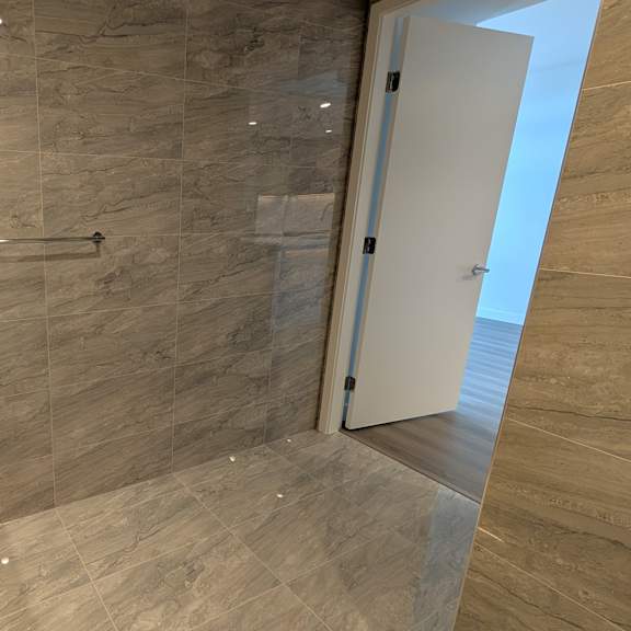 a bathroom with a sink, mirror, and tiled walls.