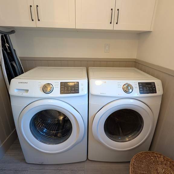 two washing machines in a small laundry room.