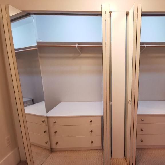 closet with two white benches and drawers.
