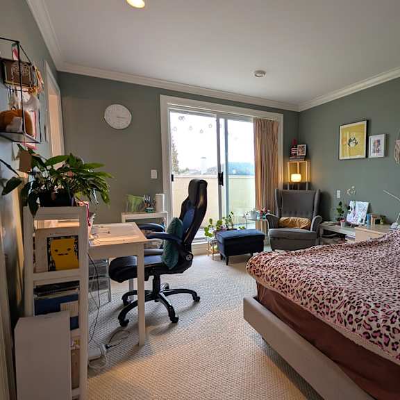 a bedroom with a bed, desk, and chair.