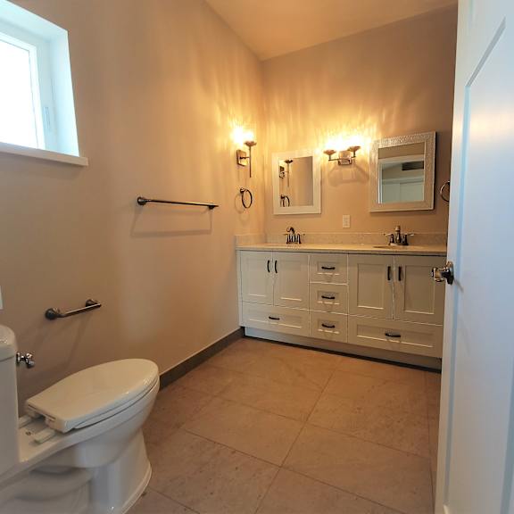 a bathroom with a toilet, sink, and mirror.