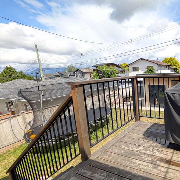 a black grill cover is on a wooden deck.