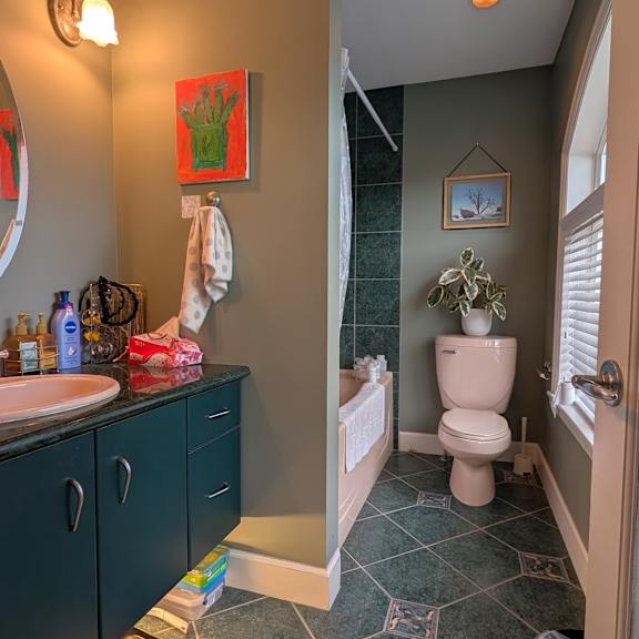 a bathroom with a toilet, sink, and mirror.