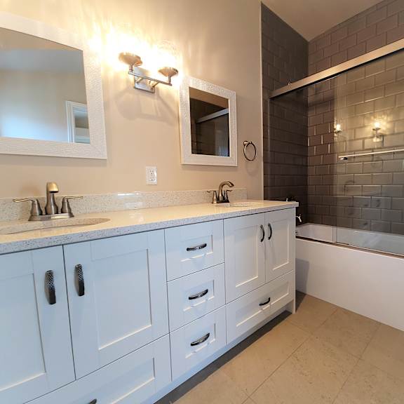 a bathroom with a white counter top and a walk in shower.