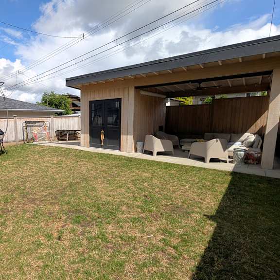a backyard with a trampoline and a shed.