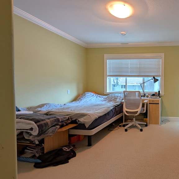 a bedroom with a bed, chair, and desk.