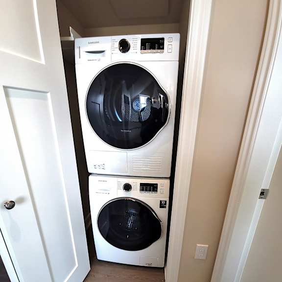a white washer and dryer stacked on top of each other in a small laundry room.