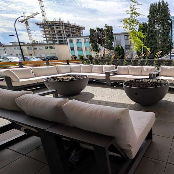 a patio with white cushions and black tables.