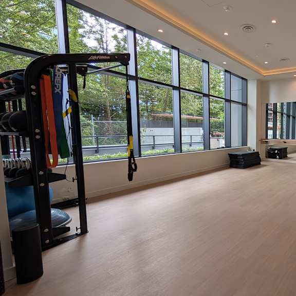 a gym with a variety of equipment and a large window.