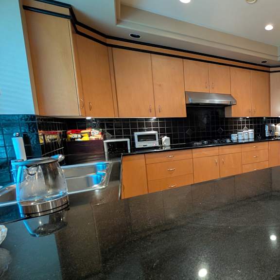 a kitchen with black countertops and wooden cabinets.