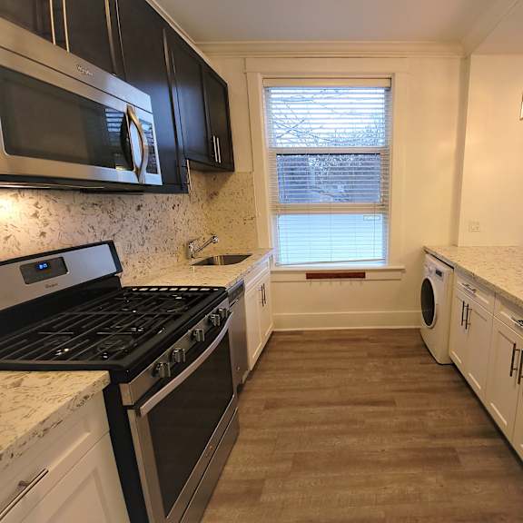 a kitchen with black appliances and white cabinets.