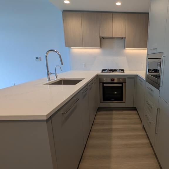 a modern kitchen with a sink and stove top oven.