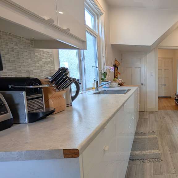a kitchen with a brick wall and wooden floors.