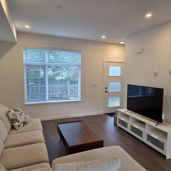 a living room with a couch, a coffee table, and a television.