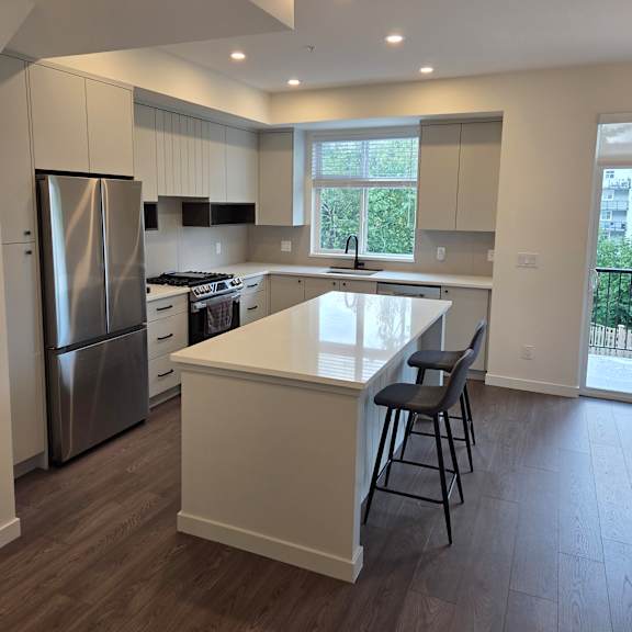 a modern kitchen with a stainless steel oven and wooden floors.