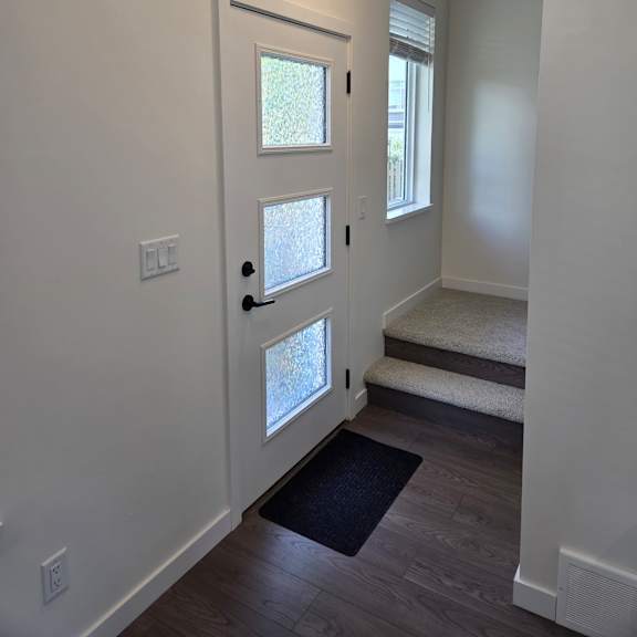 a white room with four windows and a wooden floor.