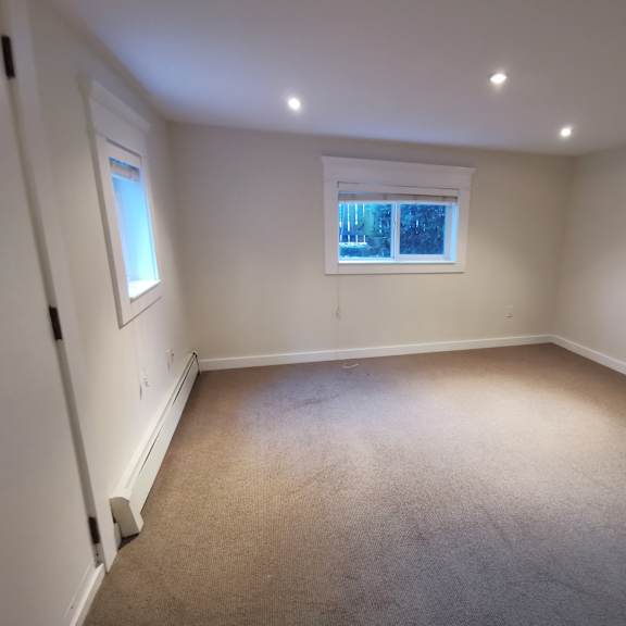 a room with a window and carpeted floor.
