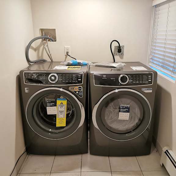 two front load washing machines in a laundry room.