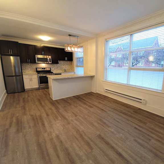 a kitchen with black cabinets and a refrigerator is visible.