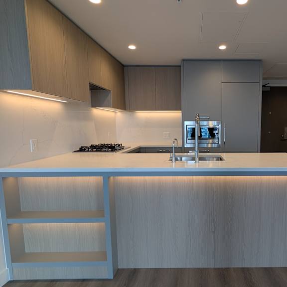 a modern kitchen with a large island and a built-in oven.