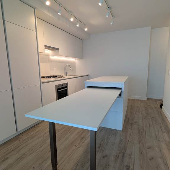 a kitchen with a table and a stove top oven.