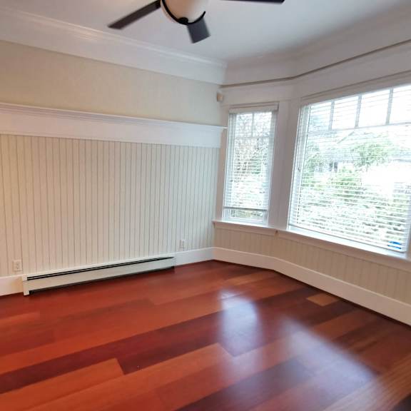 a room with a ceiling fan and a window with blinds.