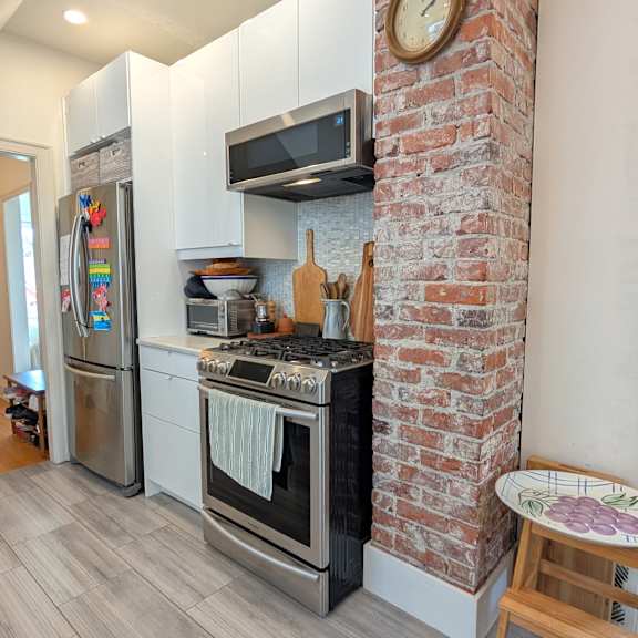 a kitchen with a brick wall and a stove top oven.
