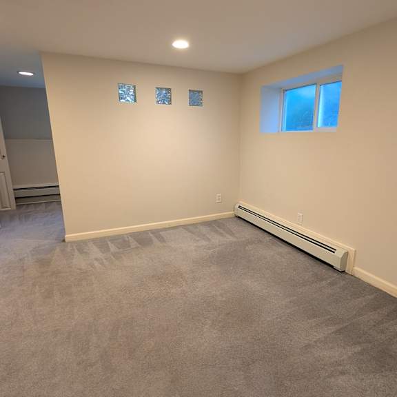 a room with a carpeted floor and a window with a white frame.