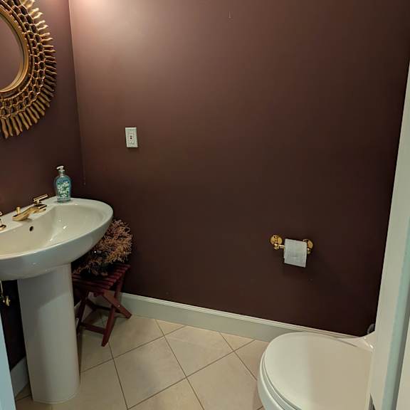 a bathroom with brown walls and a white toilet.