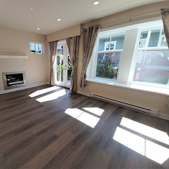 a living room with a fireplace and large windows.