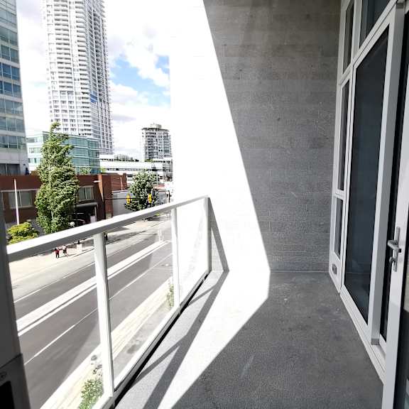a balcony with a metal railing overlooks a city street.