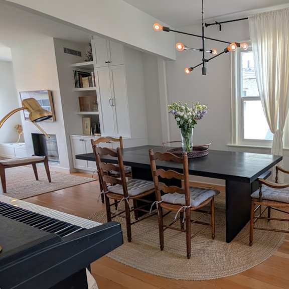 a dining room with a black table and chairs.