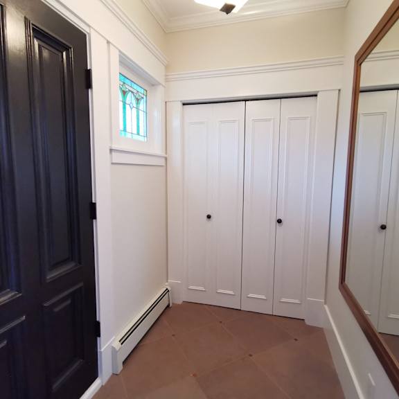 a hallway with white doors and a window.