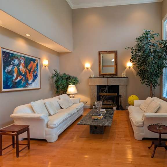 a living room with a fireplace and a painting on the wall.