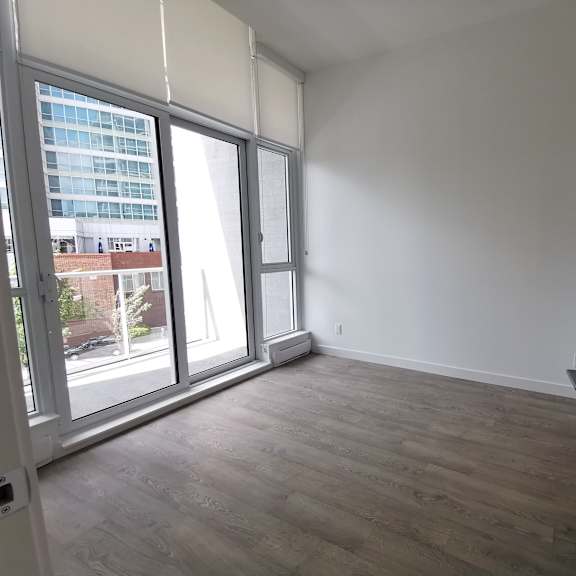 a room with a large window and a wooden floor.