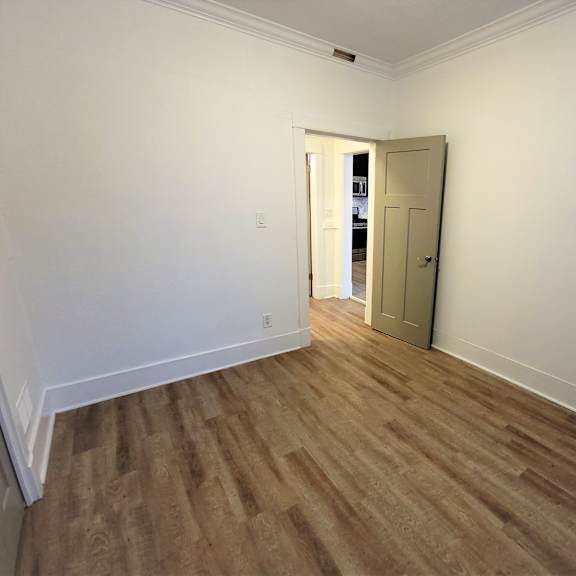 a room with a wooden floor and a white door.