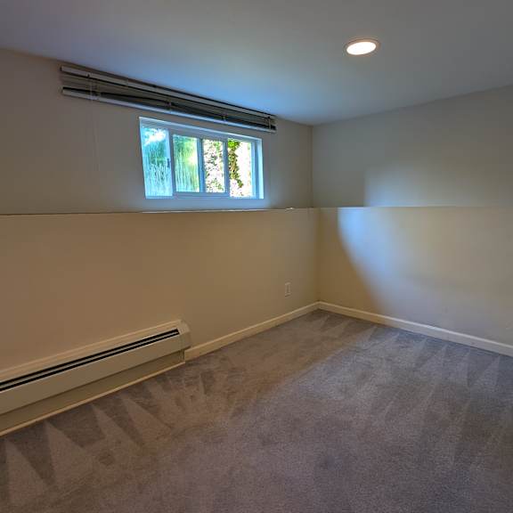 a room with a window and a radiator on the wall.