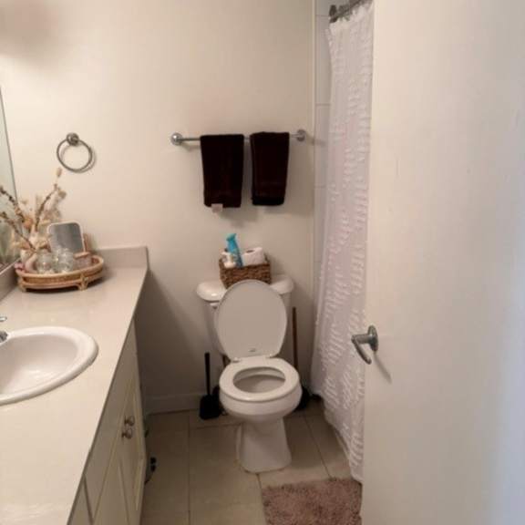 a white bathroom with a toilet, sink, and towel rack.