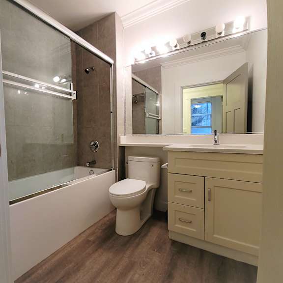 a white toilet sits in a bathroom next to a sink and a walk-in shower.