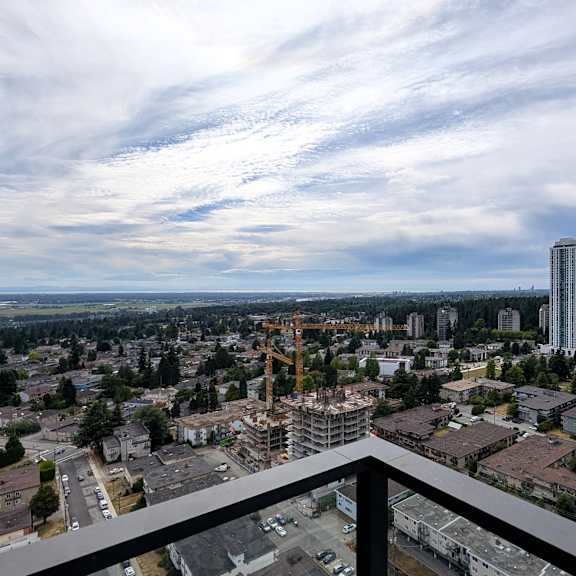 a cityscape with a mix of residential and commercial buildings under a partly cloudy sky.