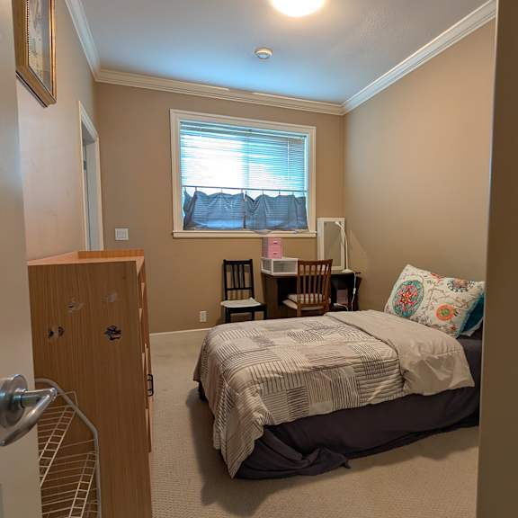 a bedroom with a bed, dresser, and window.