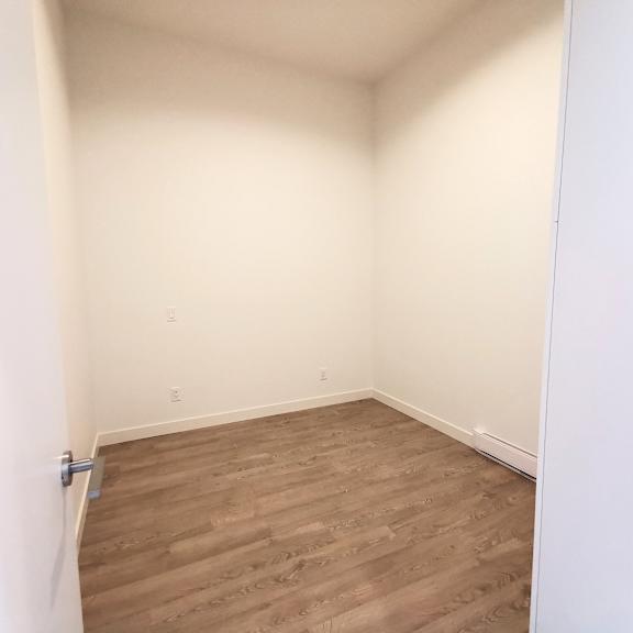 a room with wooden flooring and white walls.