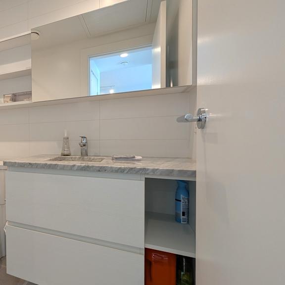 a white bathroom with a toilet, sink, and bathtub.