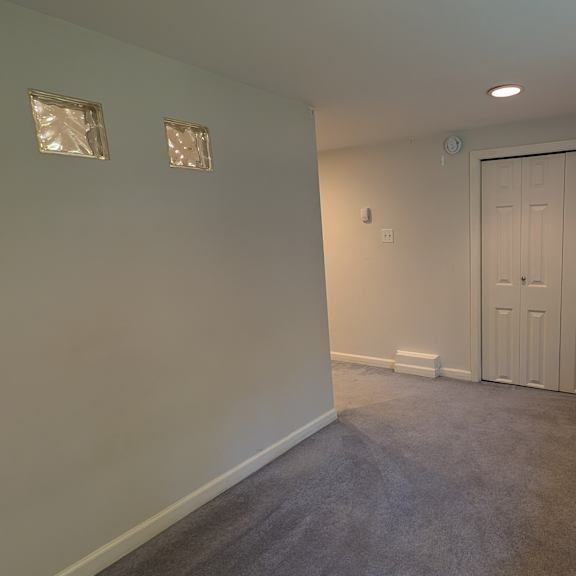 a room with a white door and a window on the right side.